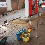 laying ground bricks in petrol station forecourt